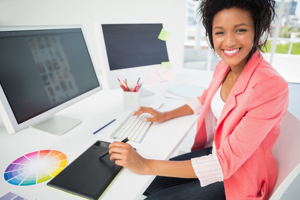Portrait of a casual female photo editor using computer in a bright office